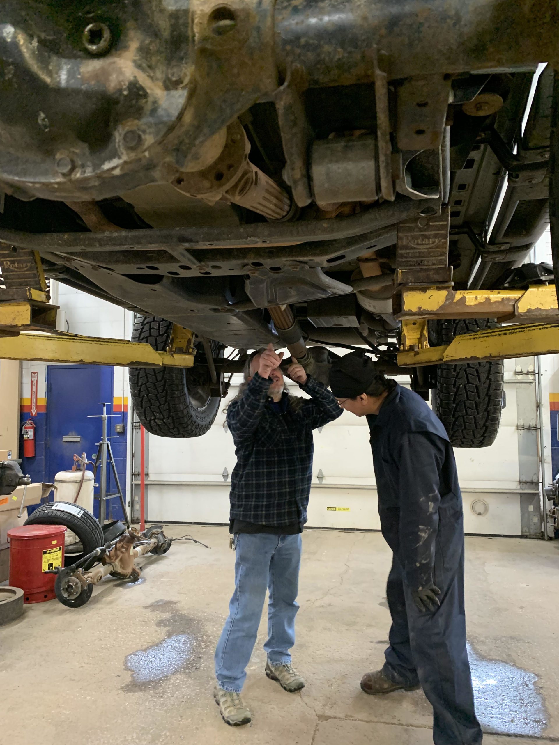 ASE Certified mechanics performing inspection on a four wheel drive vehicle